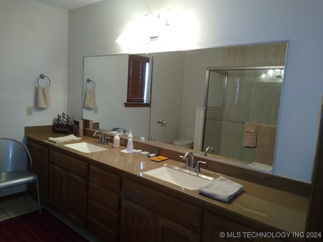 bathroom featuring tile patterned floors, an enclosed shower, vanity, and toilet