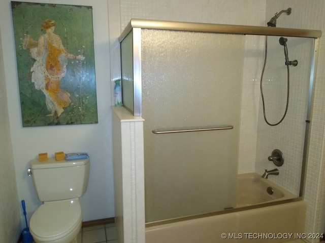 bathroom with combined bath / shower with glass door, toilet, and tile patterned flooring