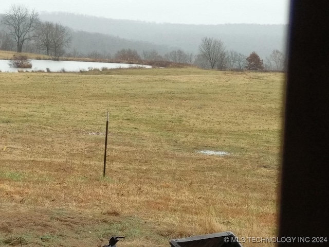 view of yard with a rural view and a water view