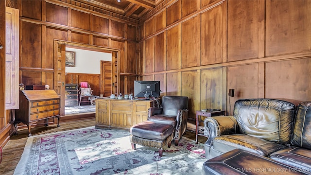 living area with wood-type flooring, wood walls, and coffered ceiling