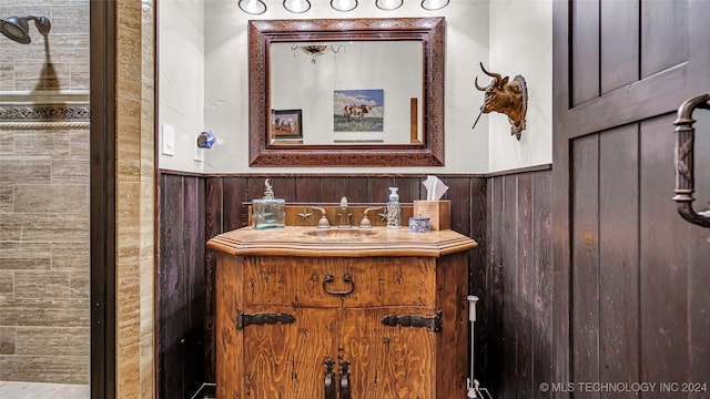 bathroom featuring wooden walls and vanity