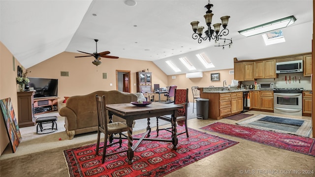 dining space featuring vaulted ceiling with skylight, beverage cooler, ceiling fan with notable chandelier, and sink