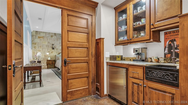 kitchen with decorative backsplash, sink, stainless steel fridge, and light stone counters