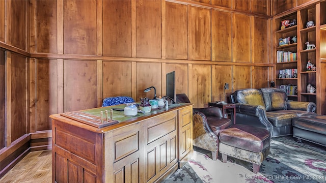 interior space with light hardwood / wood-style flooring and wood walls