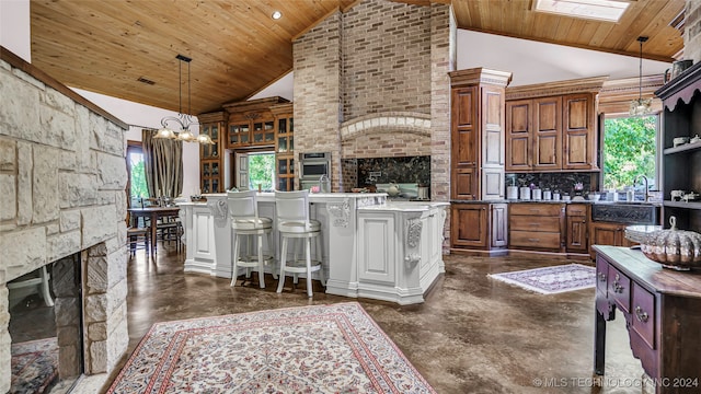 kitchen featuring high vaulted ceiling, wood ceiling, a healthy amount of sunlight, and a kitchen island