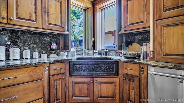 kitchen with dark stone countertops, sink, and decorative backsplash