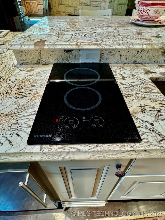 details with light stone counters and black electric cooktop