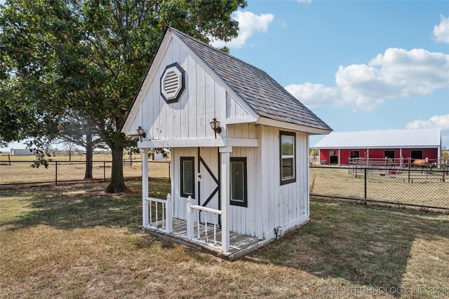 view of outbuilding with a lawn and a rural view