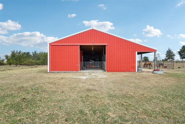 view of outdoor structure featuring a lawn and a rural view