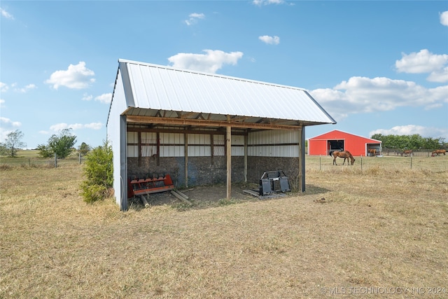 view of outdoor structure featuring a yard and a rural view