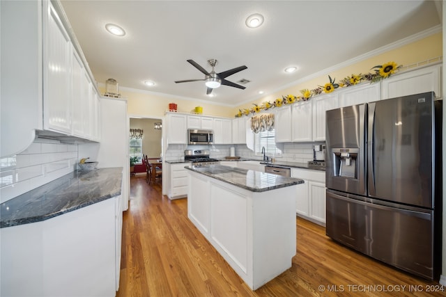 kitchen with appliances with stainless steel finishes, light hardwood / wood-style floors, a kitchen island, and white cabinets