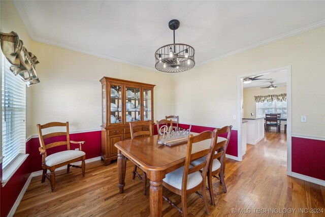 dining area featuring ceiling fan with notable chandelier, crown molding, and light hardwood / wood-style floors