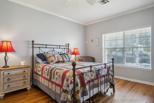 bedroom with ceiling fan, ornamental molding, and hardwood / wood-style floors