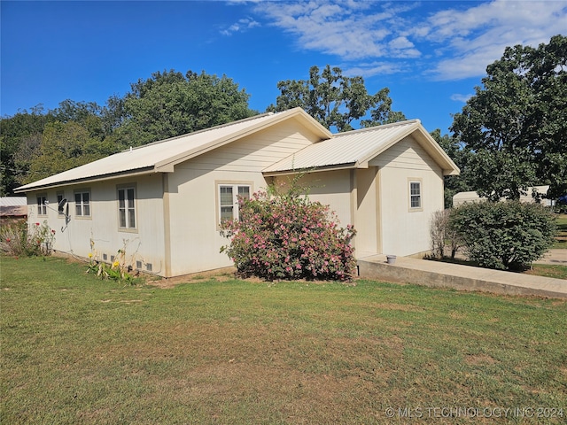 view of side of home with a yard