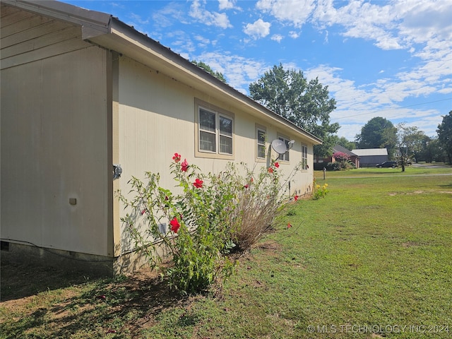 view of side of home with a lawn