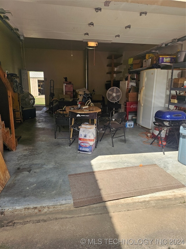 garage with a garage door opener and white fridge