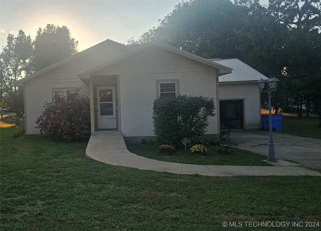 single story home featuring a garage and a yard