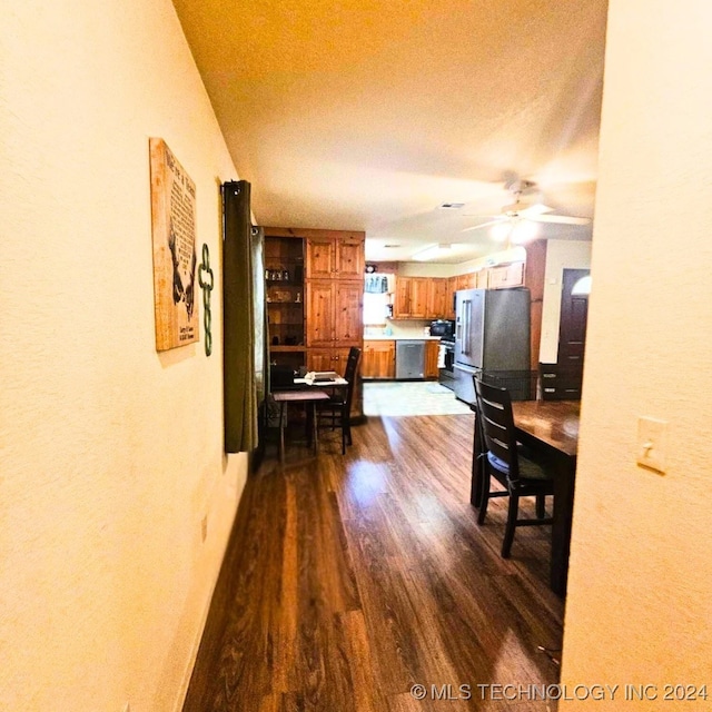 dining space with a textured ceiling, ceiling fan, and dark hardwood / wood-style flooring