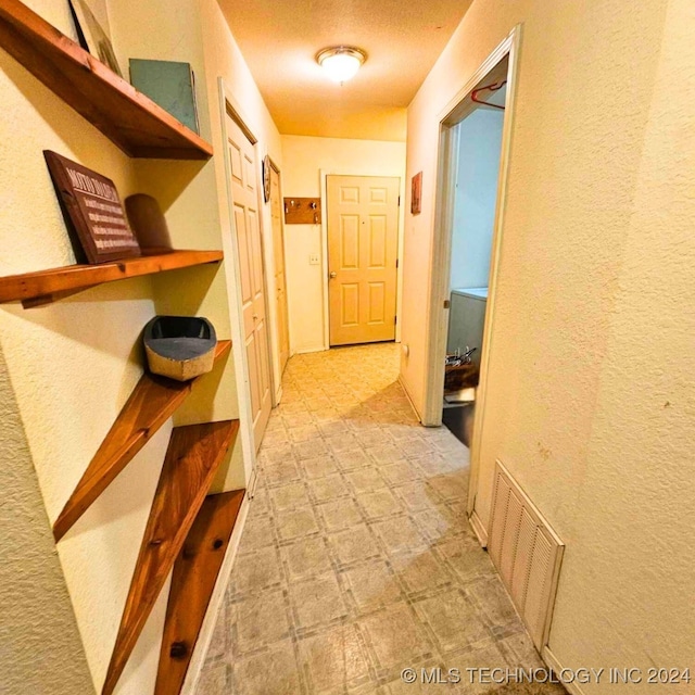 corridor featuring a textured ceiling