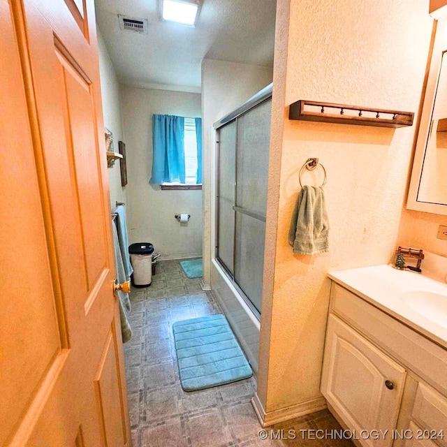 bathroom with vanity and bath / shower combo with glass door