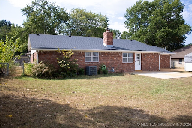 rear view of property featuring a yard, a patio, and central air condition unit