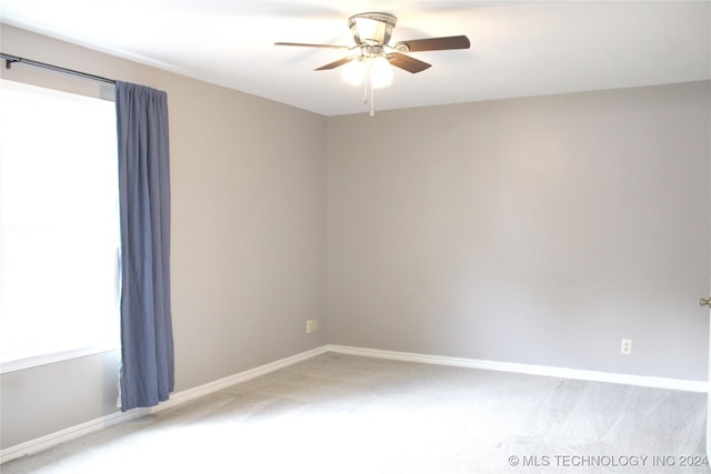 carpeted empty room featuring ceiling fan and a healthy amount of sunlight