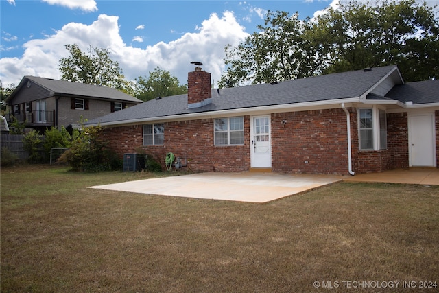 rear view of property featuring a patio, a yard, and central AC