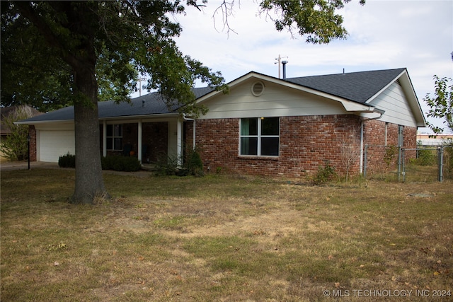 ranch-style house featuring a garage and a front lawn