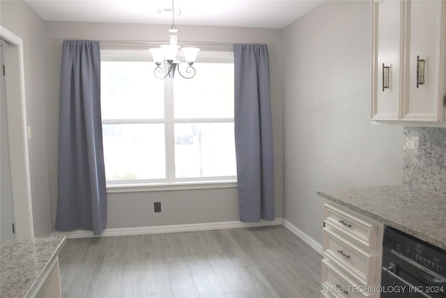 unfurnished dining area with light hardwood / wood-style floors and a chandelier