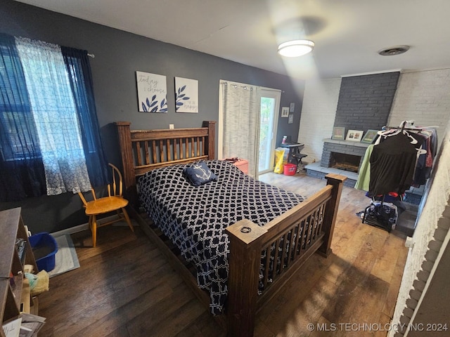 bedroom featuring a large fireplace and hardwood / wood-style floors