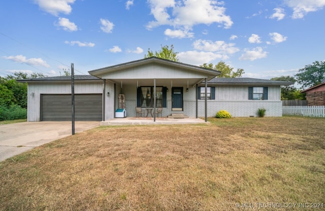 ranch-style home featuring covered porch, a front yard, and a garage