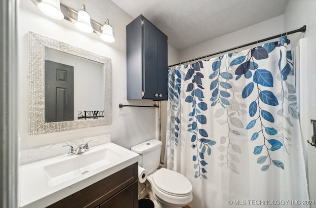 bathroom featuring vanity, toilet, a textured ceiling, and curtained shower