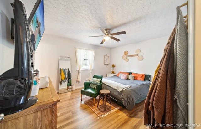 bedroom featuring wood-type flooring, a textured ceiling, and ceiling fan