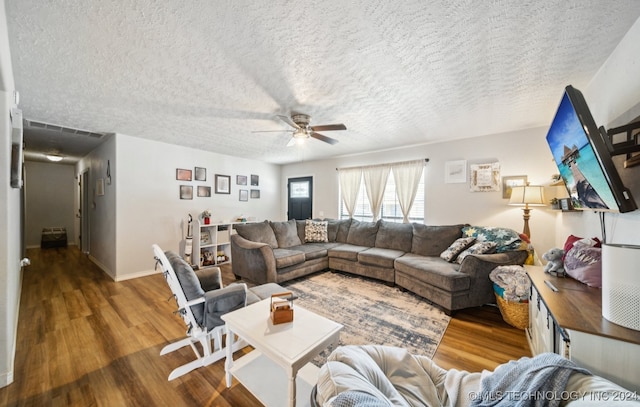 living room with a textured ceiling, ceiling fan, and hardwood / wood-style flooring