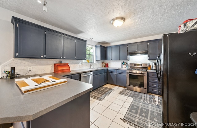 kitchen featuring a textured ceiling, stainless steel appliances, sink, and light tile patterned floors