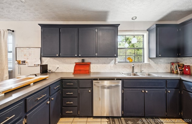 kitchen with hanging light fixtures, light tile patterned flooring, a textured ceiling, stainless steel dishwasher, and sink