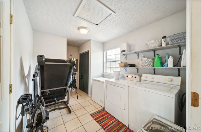 washroom with a textured ceiling, light tile patterned flooring, and separate washer and dryer