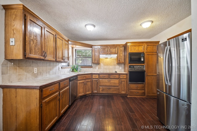 kitchen featuring backsplash, tile countertops, black appliances, and dark hardwood / wood-style floors