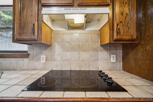 kitchen featuring tasteful backsplash, tile countertops, and black electric cooktop