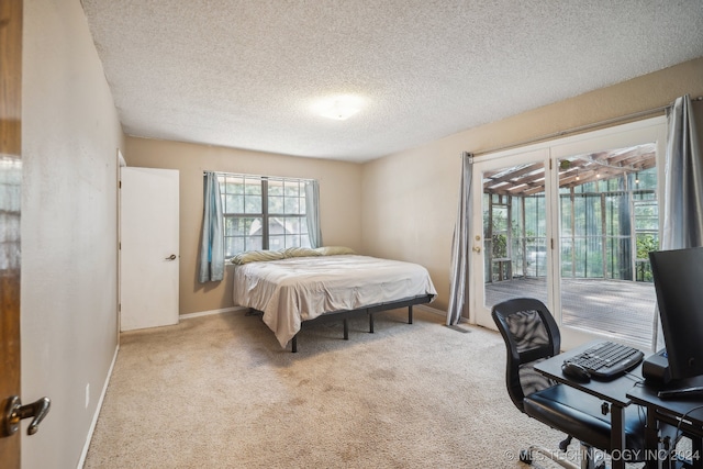 carpeted bedroom featuring a textured ceiling and access to exterior