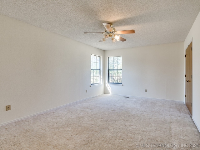 carpeted spare room with ceiling fan and a textured ceiling