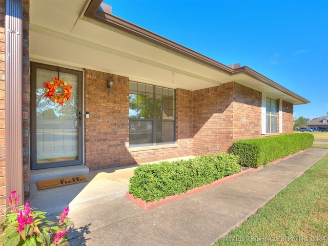 view of exterior entry featuring covered porch