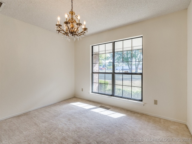 spare room with light carpet and a textured ceiling