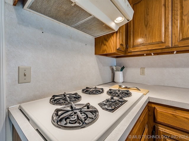 kitchen with white gas range oven and range hood