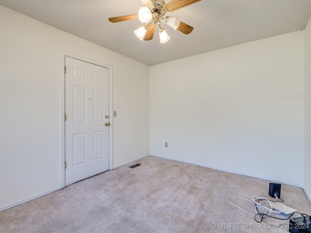 carpeted empty room featuring a textured ceiling and ceiling fan