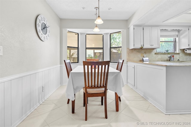 dining space with light tile patterned floors and a textured ceiling