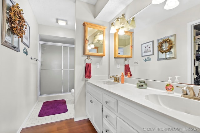 bathroom featuring hardwood / wood-style flooring, vanity, toilet, and walk in shower