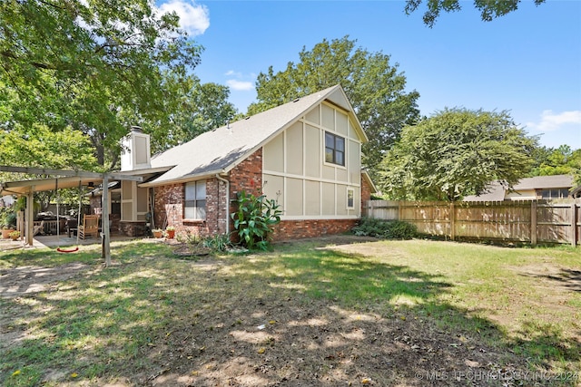 view of side of property with a patio area and a yard