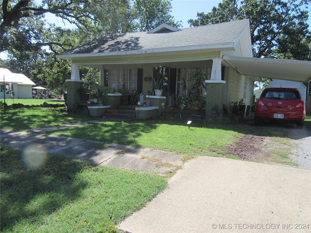 bungalow-style house with a carport, a porch, and a front yard