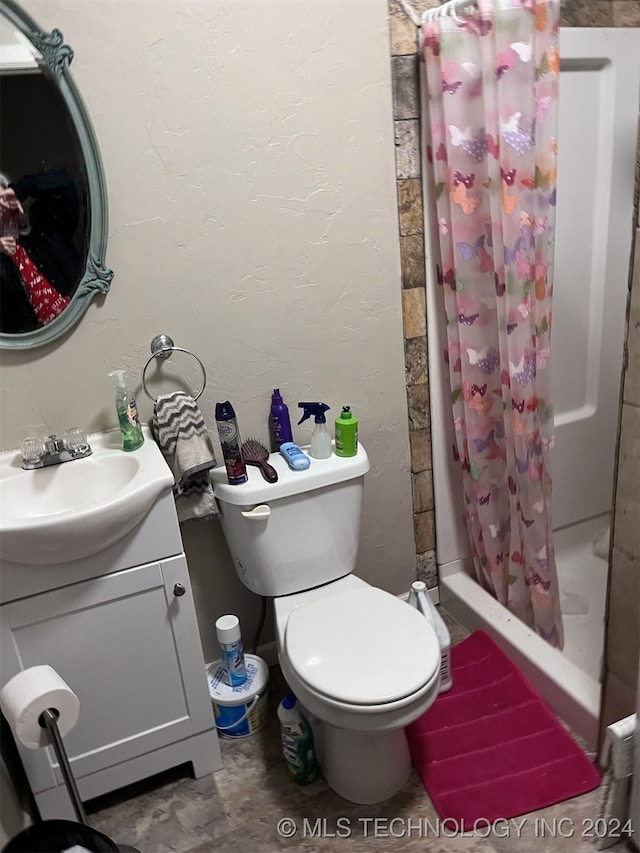 bathroom with toilet, vanity, and curtained shower